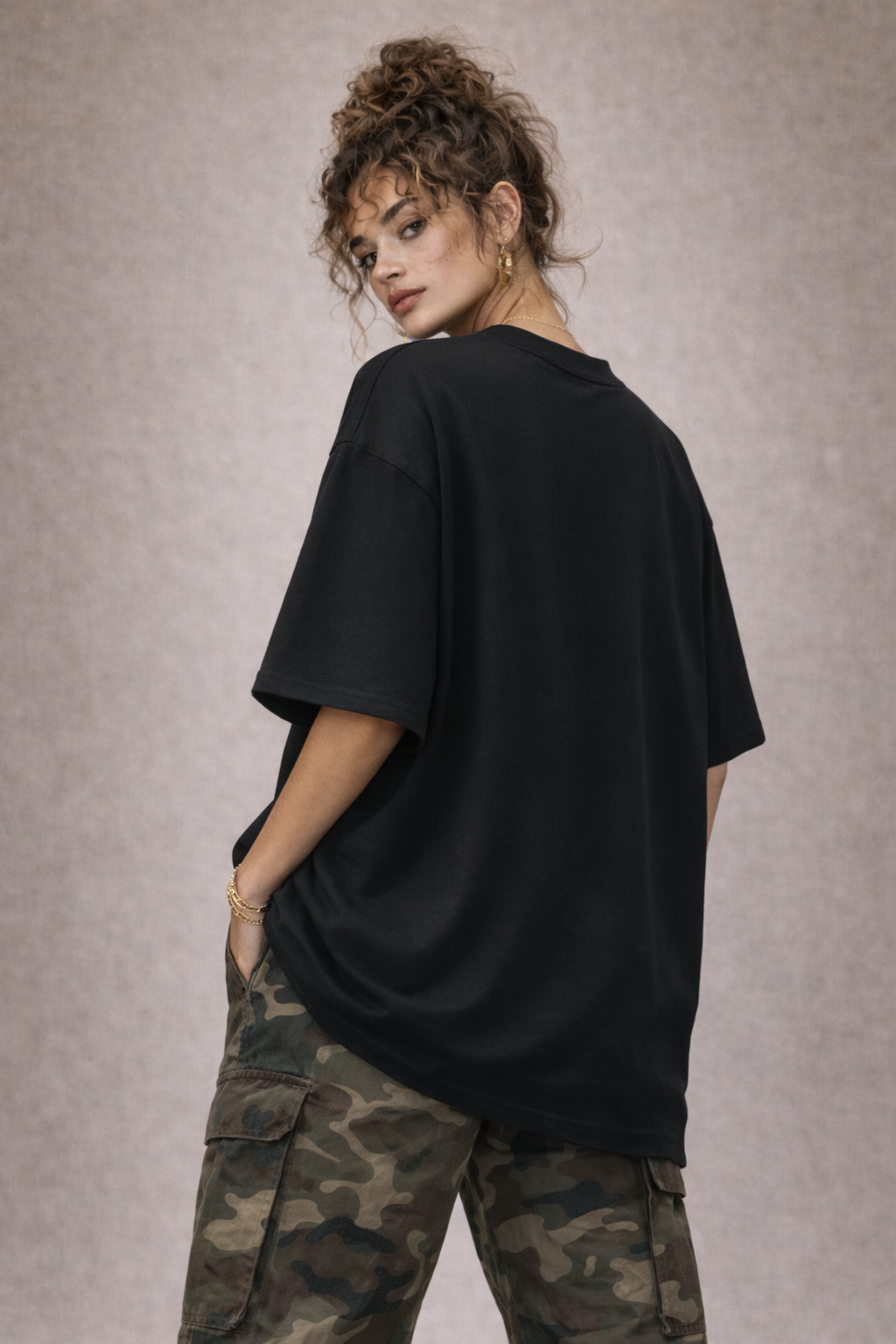 Back view of oversized black women’s t-shirt with relaxed fit, minimalist streetwear style.