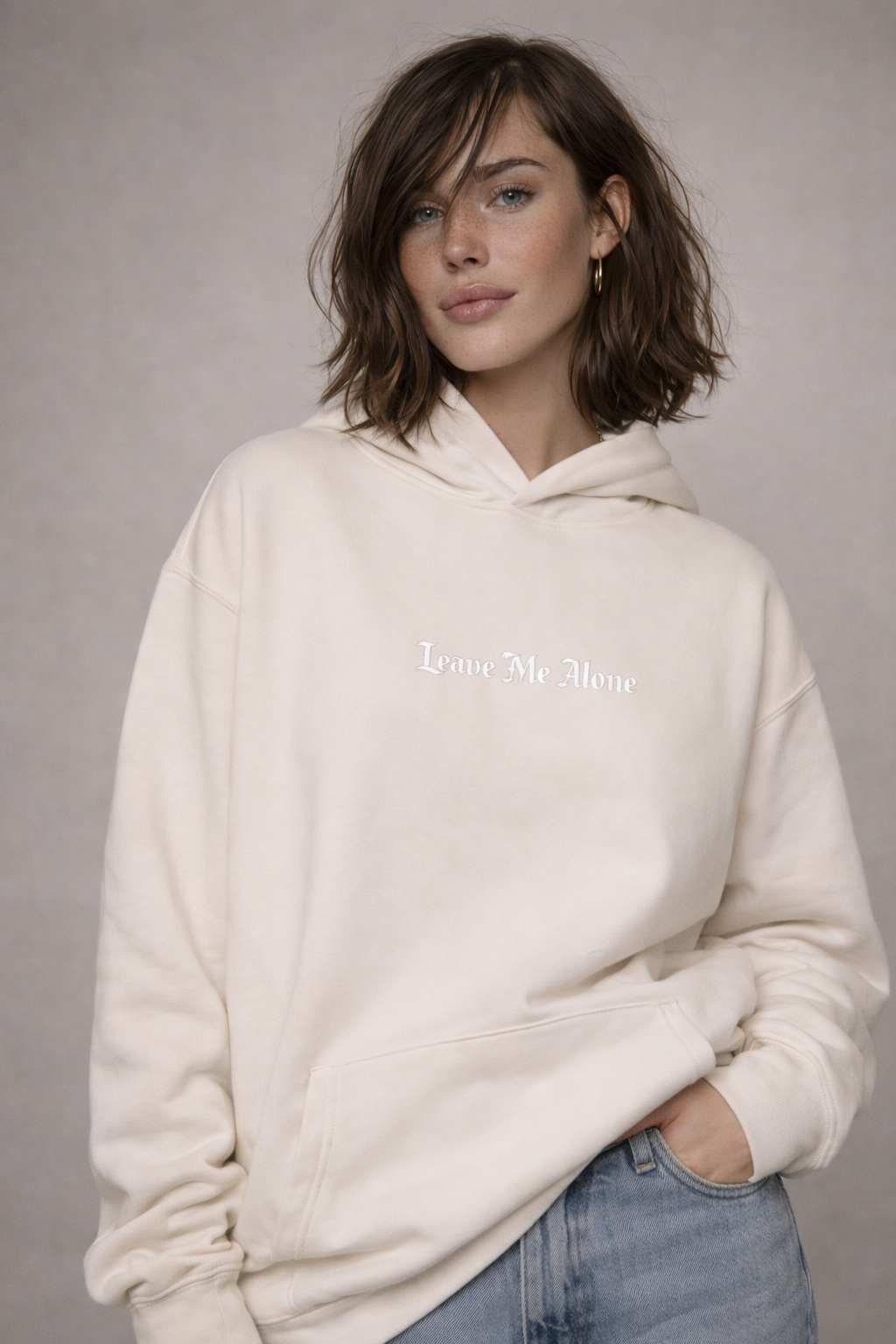 female model casual pose wearing oversized beige graphic streetwear hoodie minimal streetwear hoodie streetwear fashion