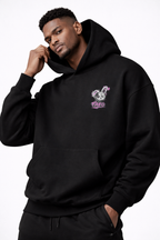male model front pose wearing oversized black graphic streetwear hoodie minimal chest logo streetwear fashion