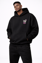 male model casual pose wearing oversized black graphic streetwear hoodie minimal chest graphic urban streetwear outfit