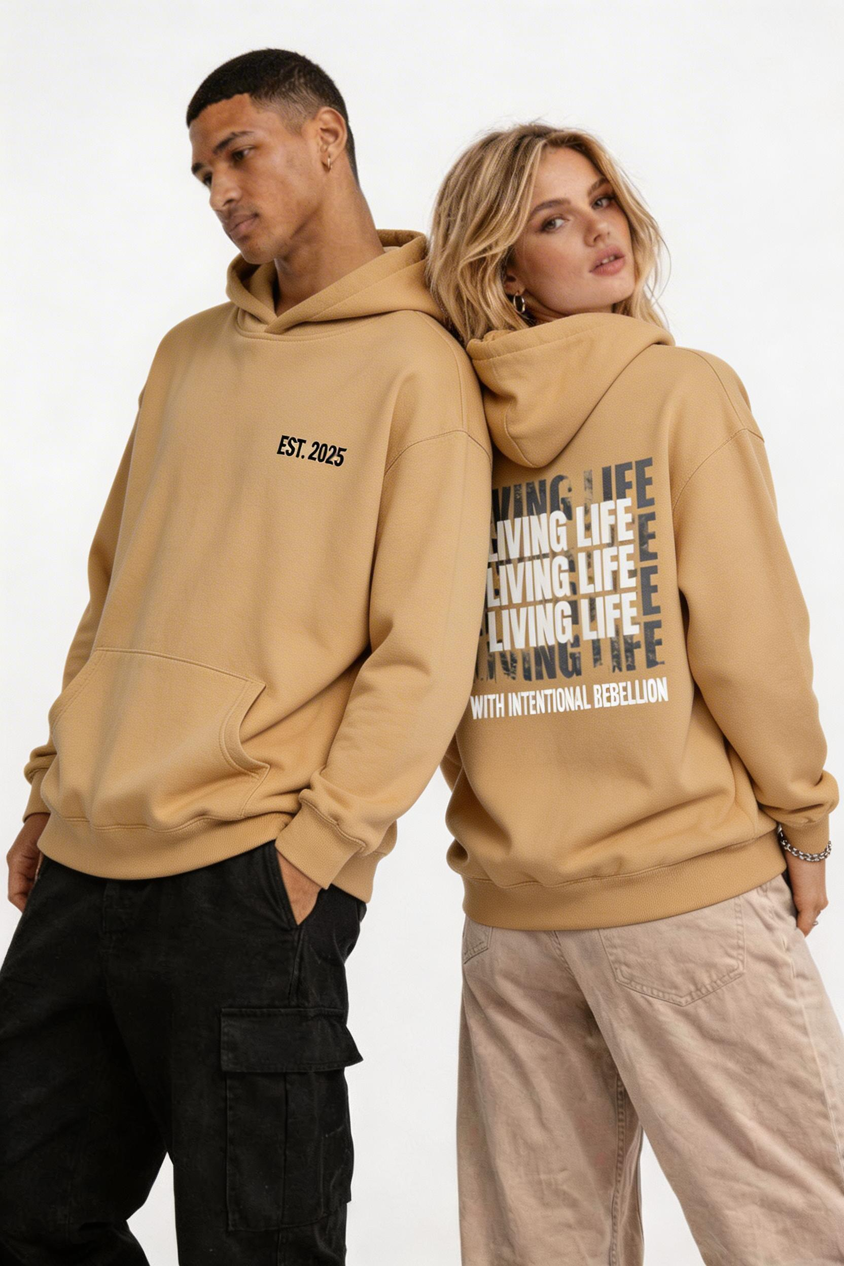 male and female models side pose wearing oversized brown graphic hoodie living life typography design streetwear fashion