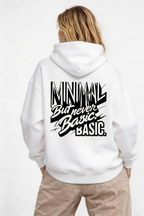 female model back pose wearing oversized white graphic hoodie minimal but never basic typography design urban streetwear outfit