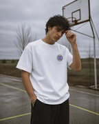 male model posing outdoor basketball court wearing oversized white graphic t shirt 90s era streetwear fashion