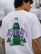 male model close up back view wearing white oversized graphic t shirt nineties culture retro bottle artwork streetwear fashion