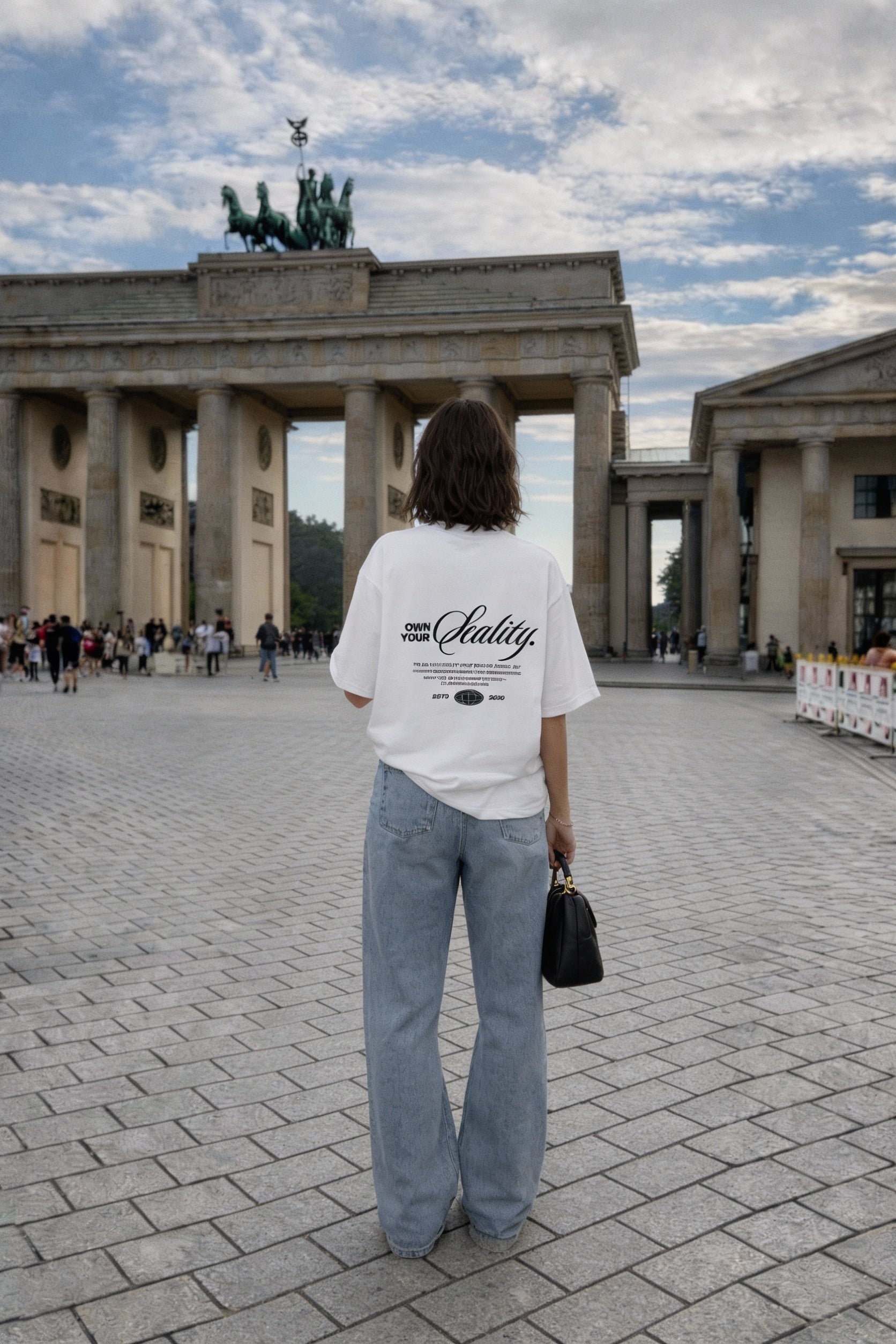female model back view wearing oversized white graphic streetwear t shirt own your reality back print urban streetwear outfit