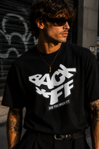 male model close up wearing black oversized graphic t shirt back off statement typography streetwear fashion