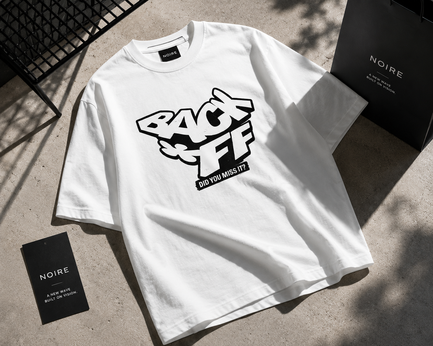 flat lay angled view oversized white graphic t shirt back off statement print urban streetwear outfit