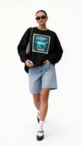 female model walking wearing oversized black graphic sweatshirt soft face sharp mind streetwear outfit with denim shorts