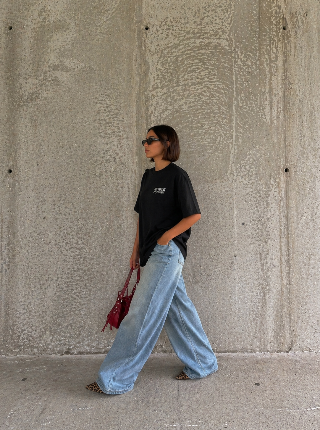 side view model walking wearing oversized black graphic t-shirt streetwear fashion