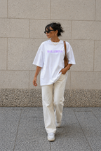 model walking in oversized white ballerina graphic t-shirt cream pants and sunglasses streetwear fashion