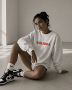 model sitting on floor wearing oversized white ballerina sweatshirt red front print urban streetwear outfit