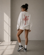 model back view standing wearing oversized white ballerina graphic sweatshirt red sketch print urban streetwear outfit