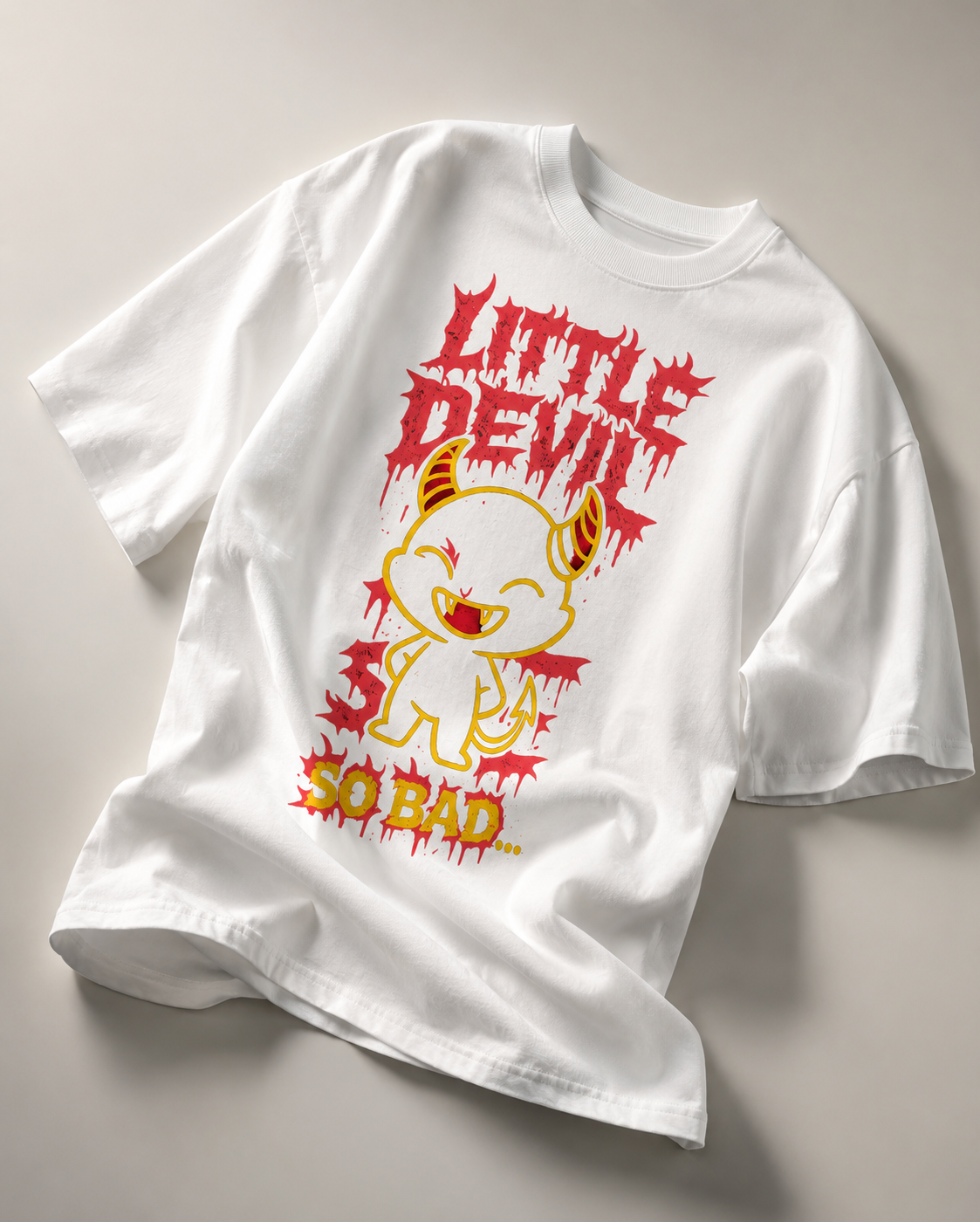 oversized white graphic t shirt laid flat featuring little devil cartoon artwork with bold red typography and relaxed streetwear aesthetic
