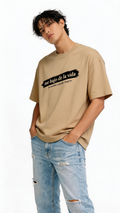 male model wearing oversized beige graphic streetwear t-shirt me bajo de la vida aviseme cuando mejore design urban streetwear outfit