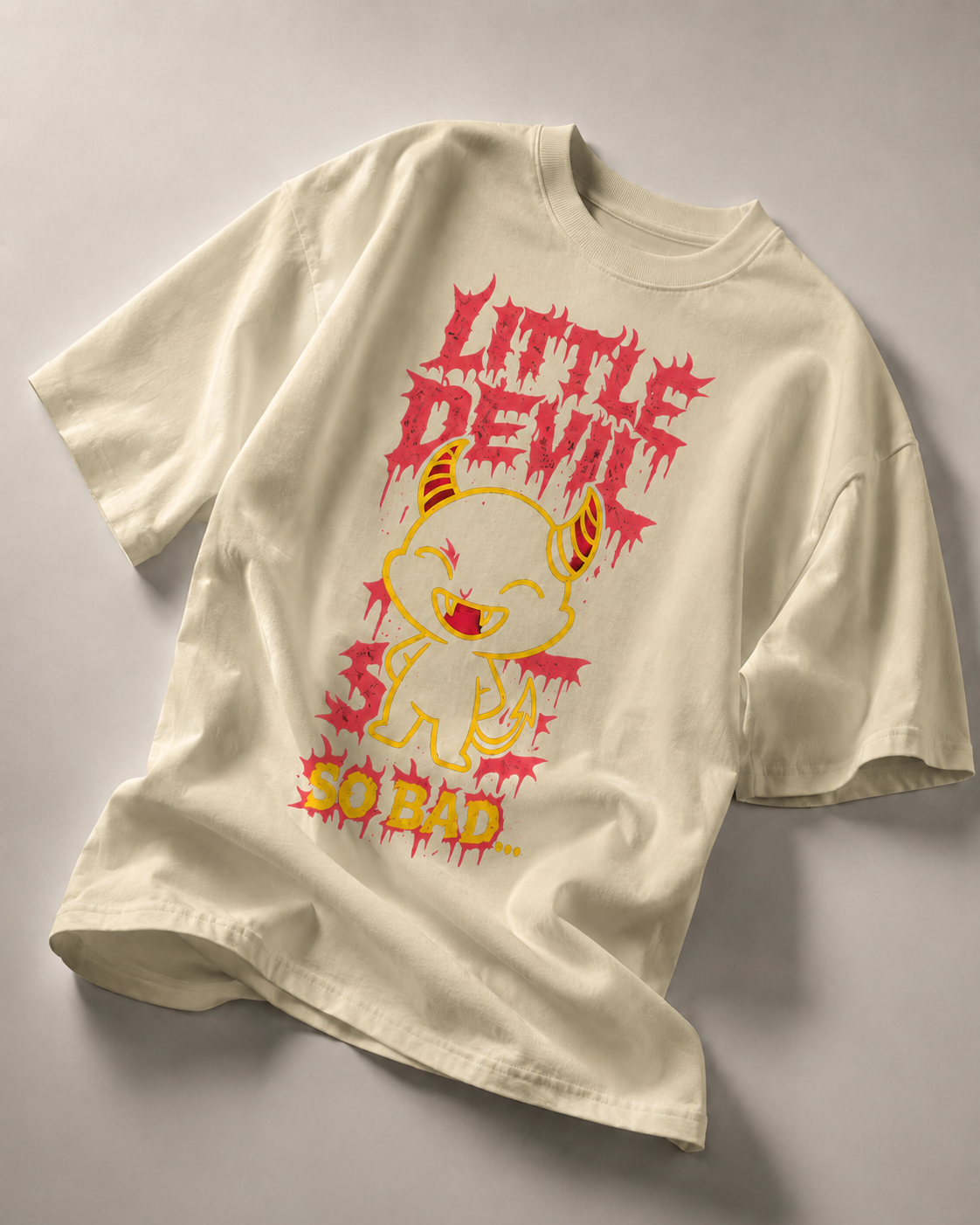 sand beige oversized graphic t shirt with little devil cartoon print and bold graphic lettering relaxed urban streetwear look