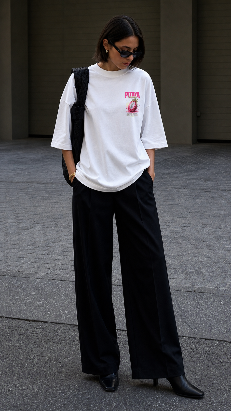 model looking down front view wearing oversized white graphic t shirt pitaya chest logo streetwear fashion