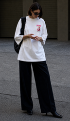 model adjusting hands front view wearing oversized white graphic t shirt pitaya exotic chest graphic urban streetwear outfit