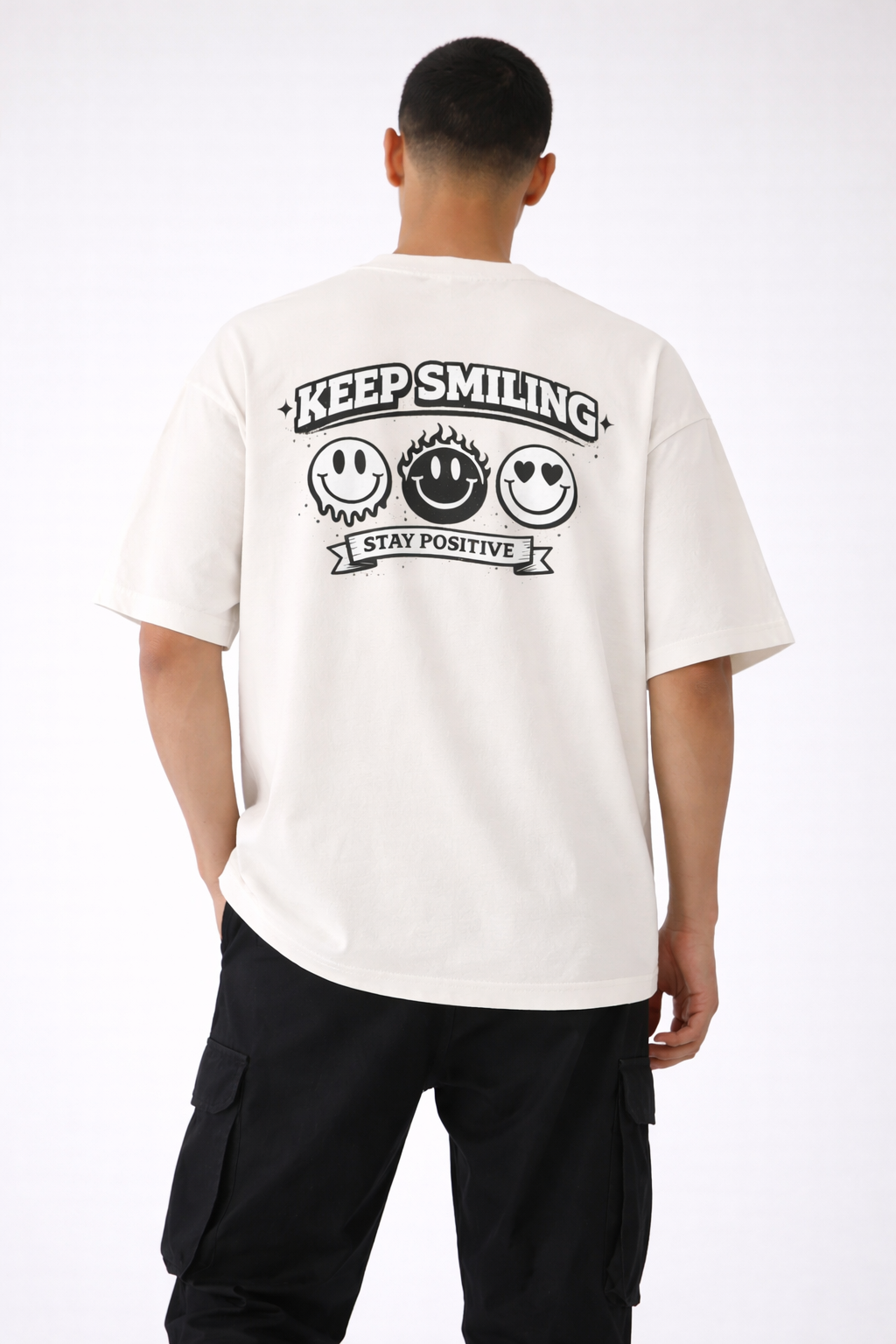 male model back view wearing oversized beige graphic streetwear t-shirt keep smiling stay positive back print design