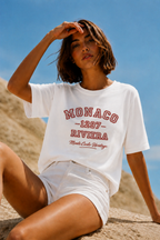 model sitting pose wearing relaxed fit white graphic t shirt monaco riviera print urban streetwear outfit