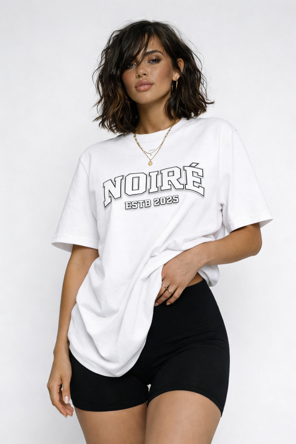 Woman wearing white oversized Noiré varsity logo streetwear t-shirt, casual minimalist outfit