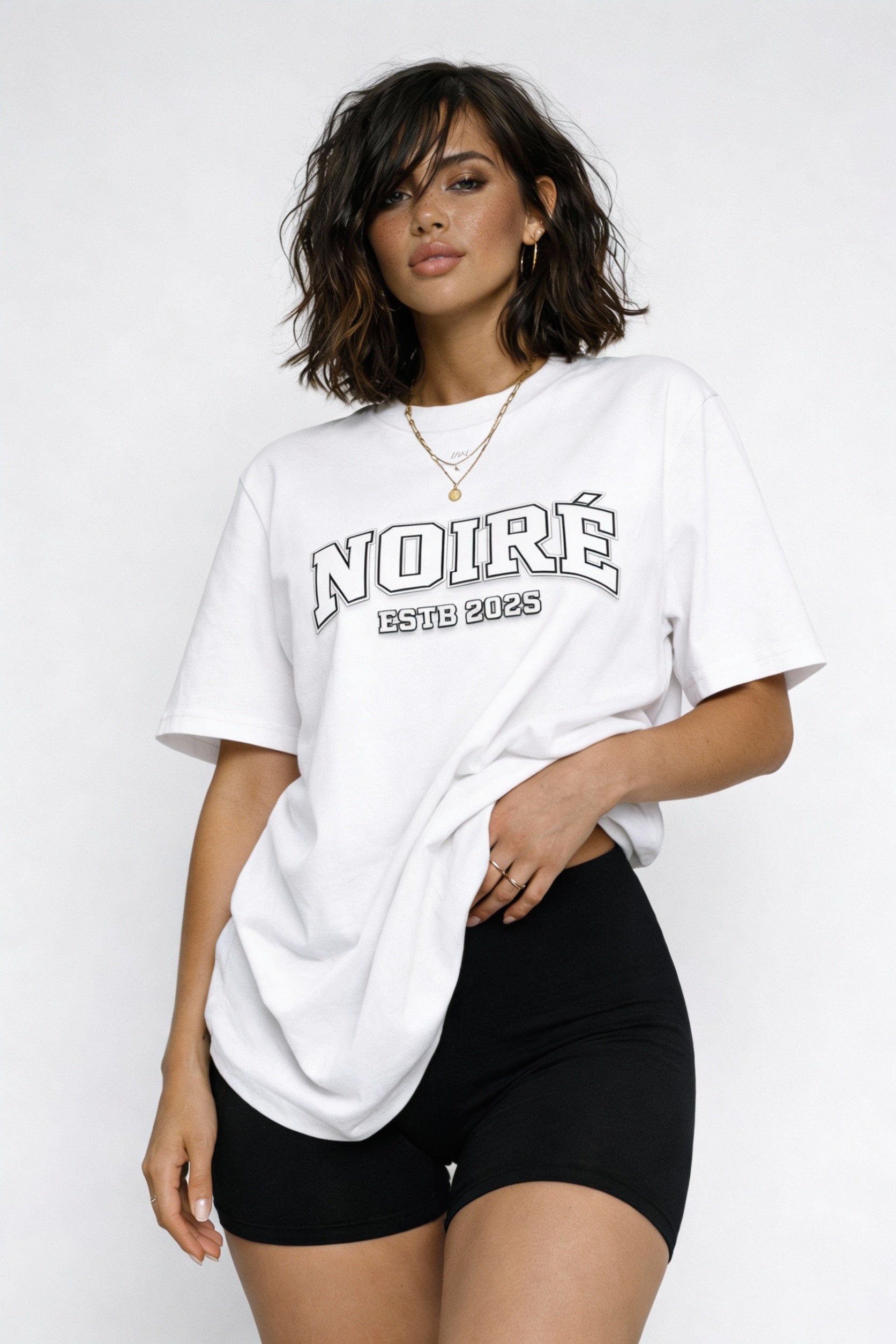 Woman wearing white oversized Noiré varsity logo streetwear t-shirt, casual minimalist outfit