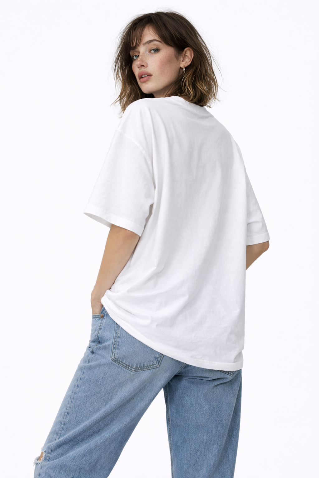 Back view of oversized white streetwear graphic t-shirt worn by female model minimalist streetwear outfit