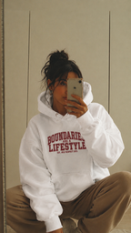 mirror selfie female model sitting pose wearing oversized white graphic hoodie boundaries are a lifestyle urban streetwear outfit