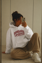 model seated on floor wearing oversized white statement hoodie casual urban streetwear outfit