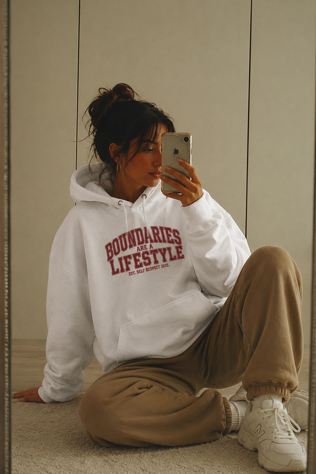 model seated on floor wearing oversized white statement hoodie casual urban streetwear outfit