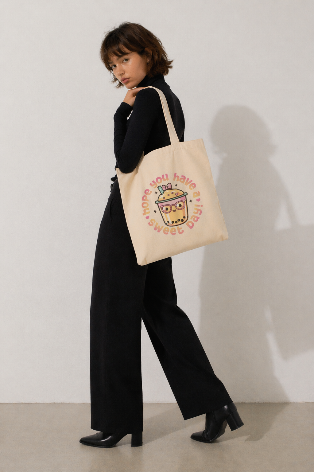 model walking pose carrying beige tote bag with bubble tea graphic relaxed fit outfit neutral tones fashion
