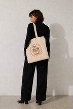 model back view standing wearing beige tote bag bubble tea cute graphic print minimal studio background