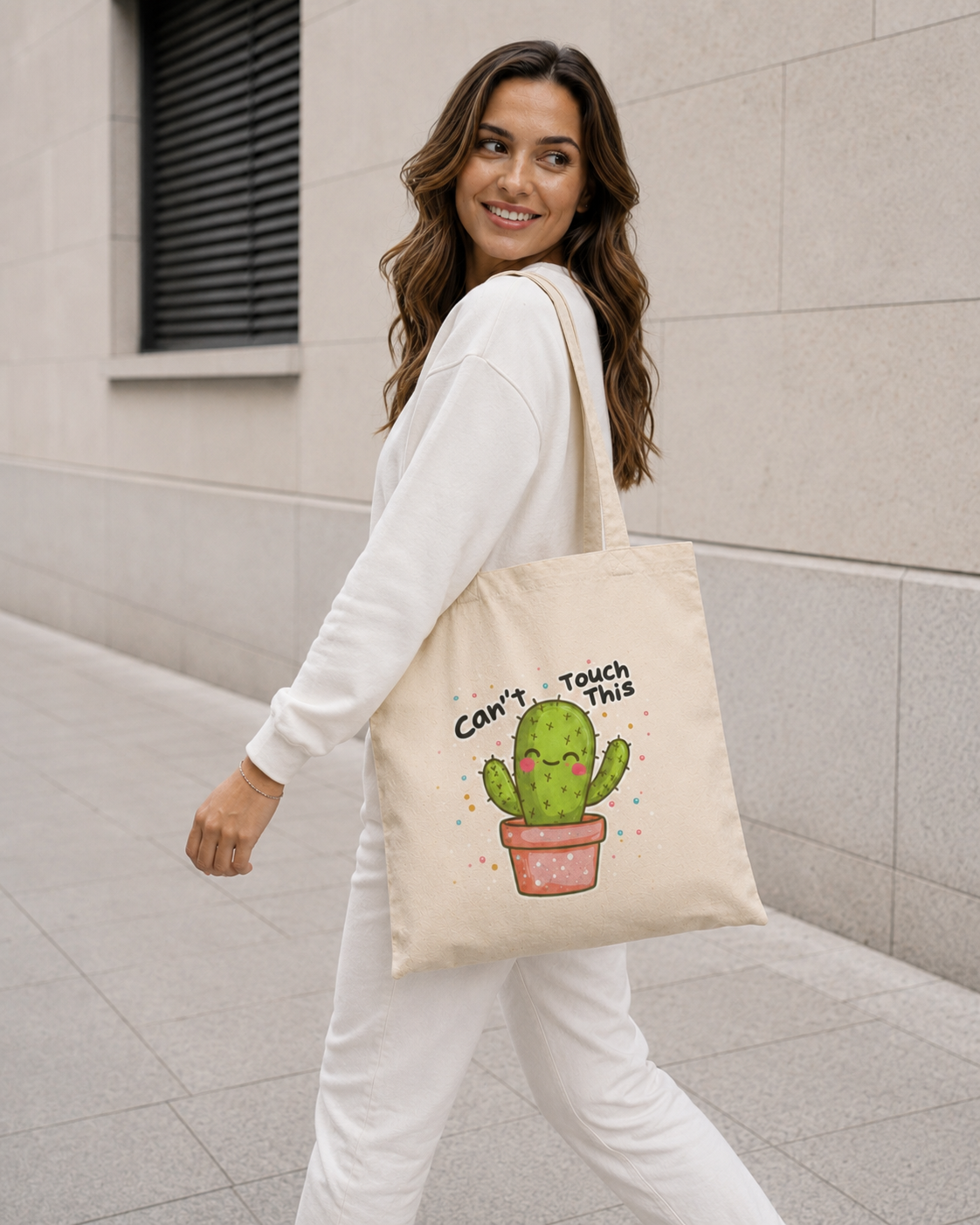 Woman carrying natural canvas Nöiré cactus graphic tote bag, lifestyle streetwear look