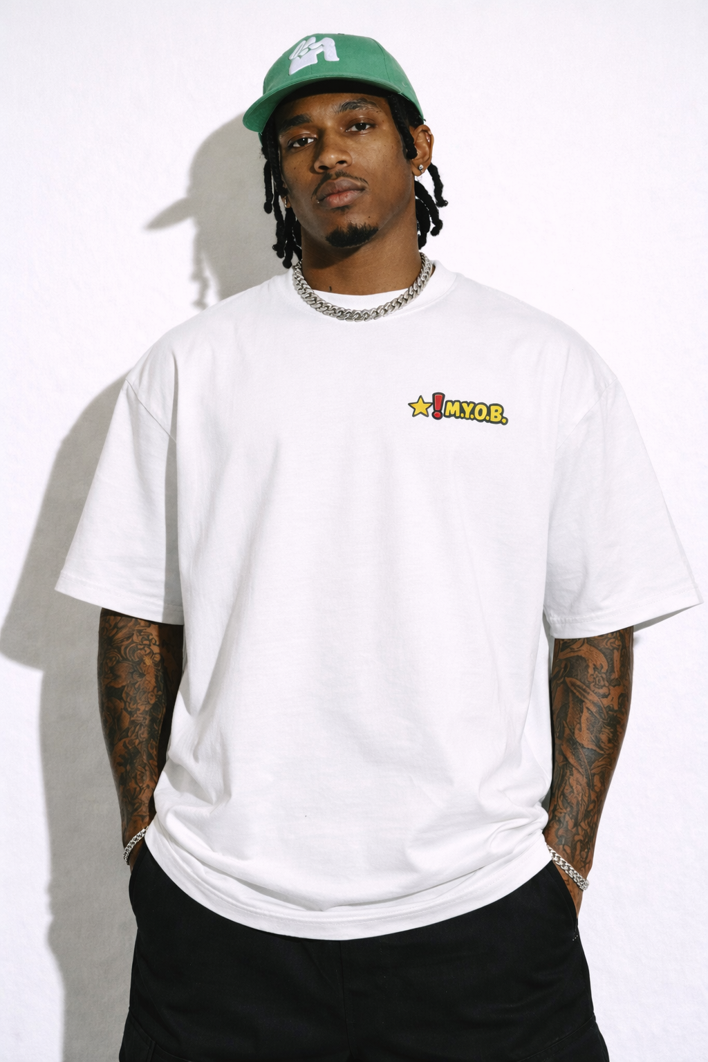 male model relaxed front pose wearing oversized white graphic streetwear t shirt MYOB chest graphic urban streetwear fashion