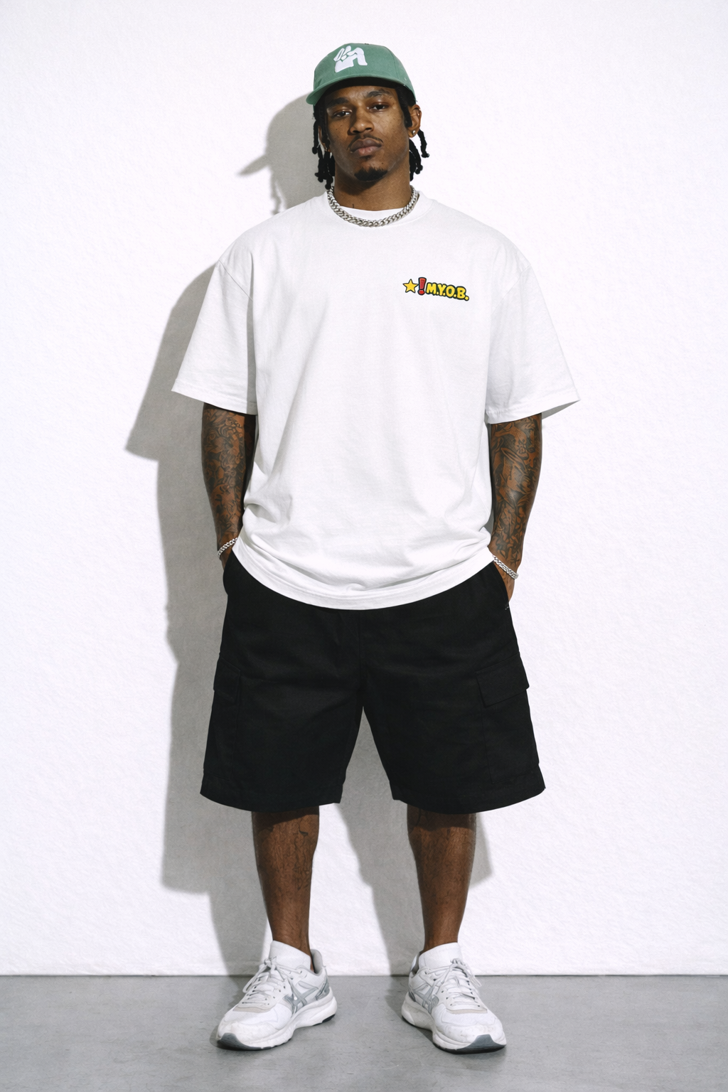 male model full body front view wearing oversized white graphic streetwear t shirt MYOB logo design urban streetwear outfit