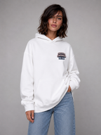 model front view wearing oversized white graphic hoodie with certified heartbreaker chest print streetwear fashion