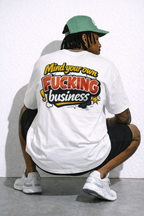 male model seated back pose wearing oversized white graphic streetwear t shirt mind your own fucking business graphic design urban streetwear outfit