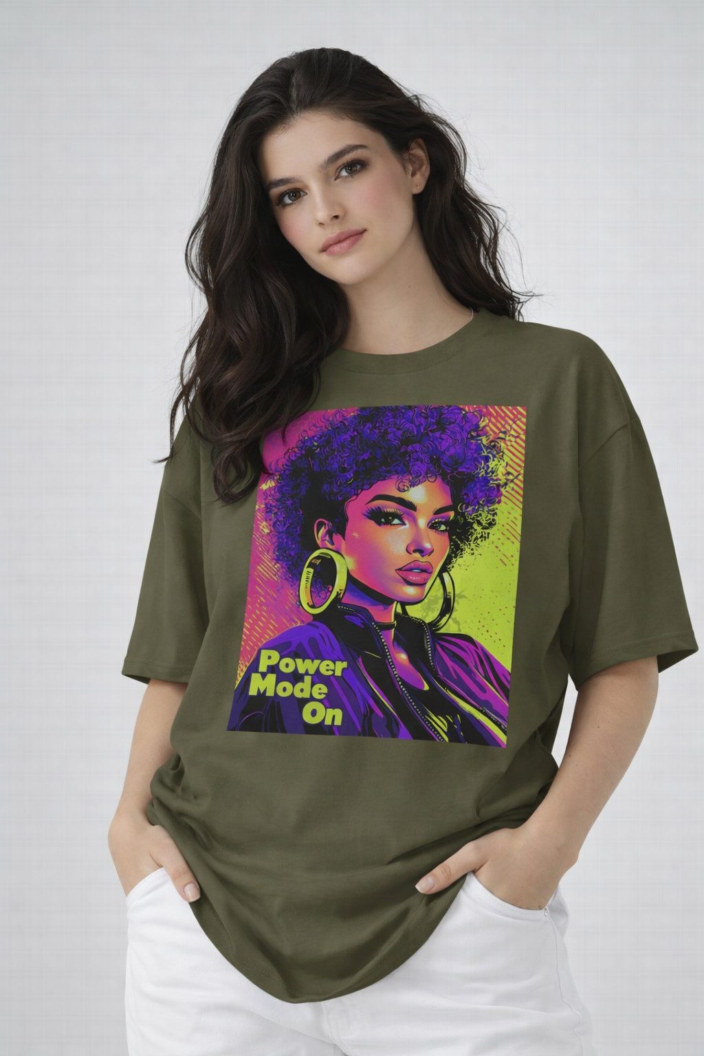Female model wearing olive green oversized t-shirt with vibrant pop-art portrait graphic, artistic streetwear style by Noiré.