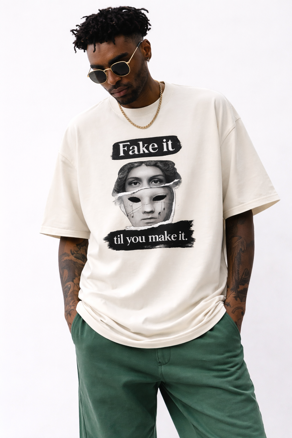 male model close front pose wearing oversized cream graphic streetwear t shirt fake it til you make it statue mask design urban streetwear outfit