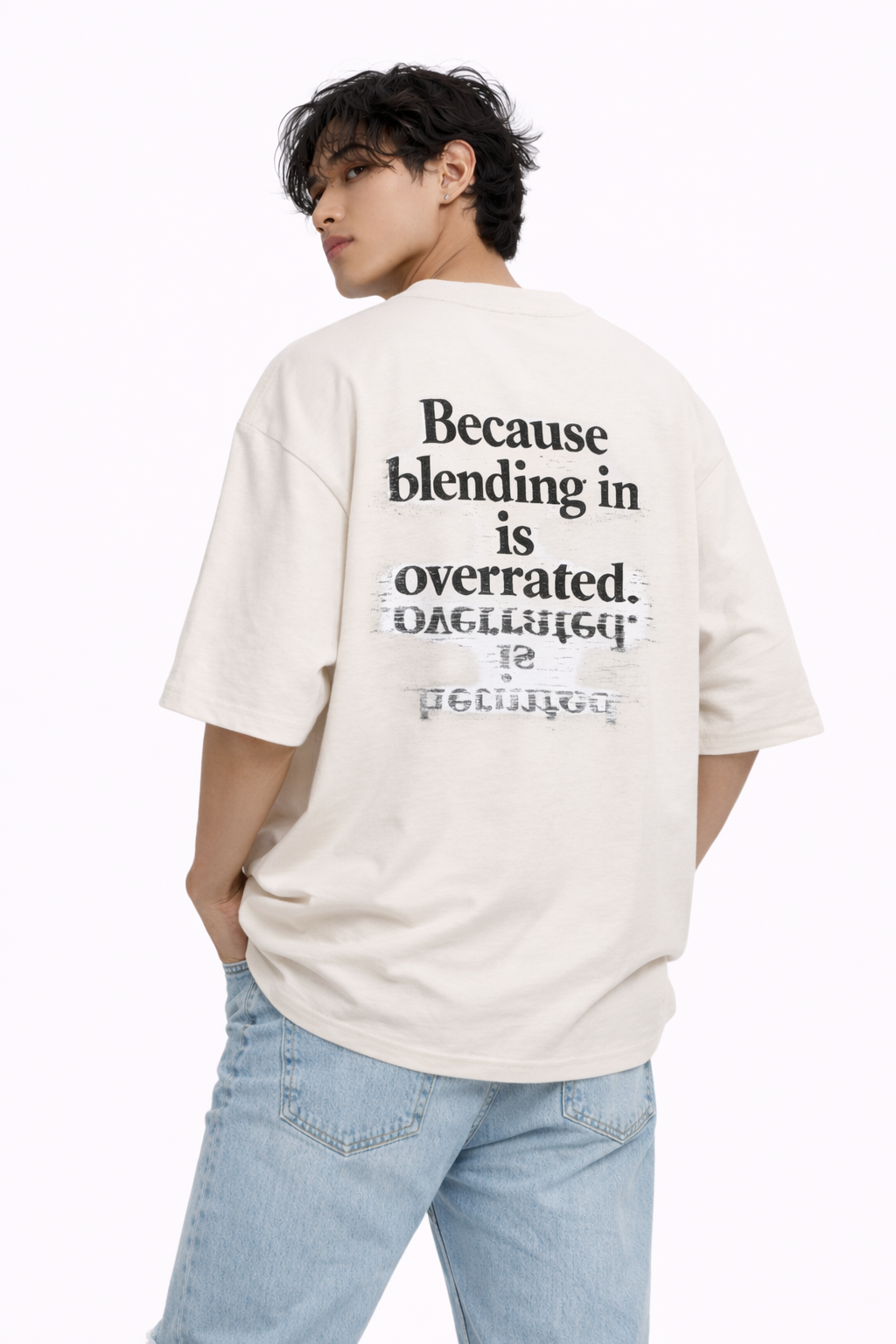 male model wearing oversized beige graphic streetwear t-shirt because blending in is overrated back print statement design