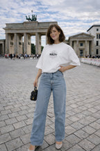 female model standing pose wearing oversized white graphic streetwear t shirt own your reality design urban streetwear fashion