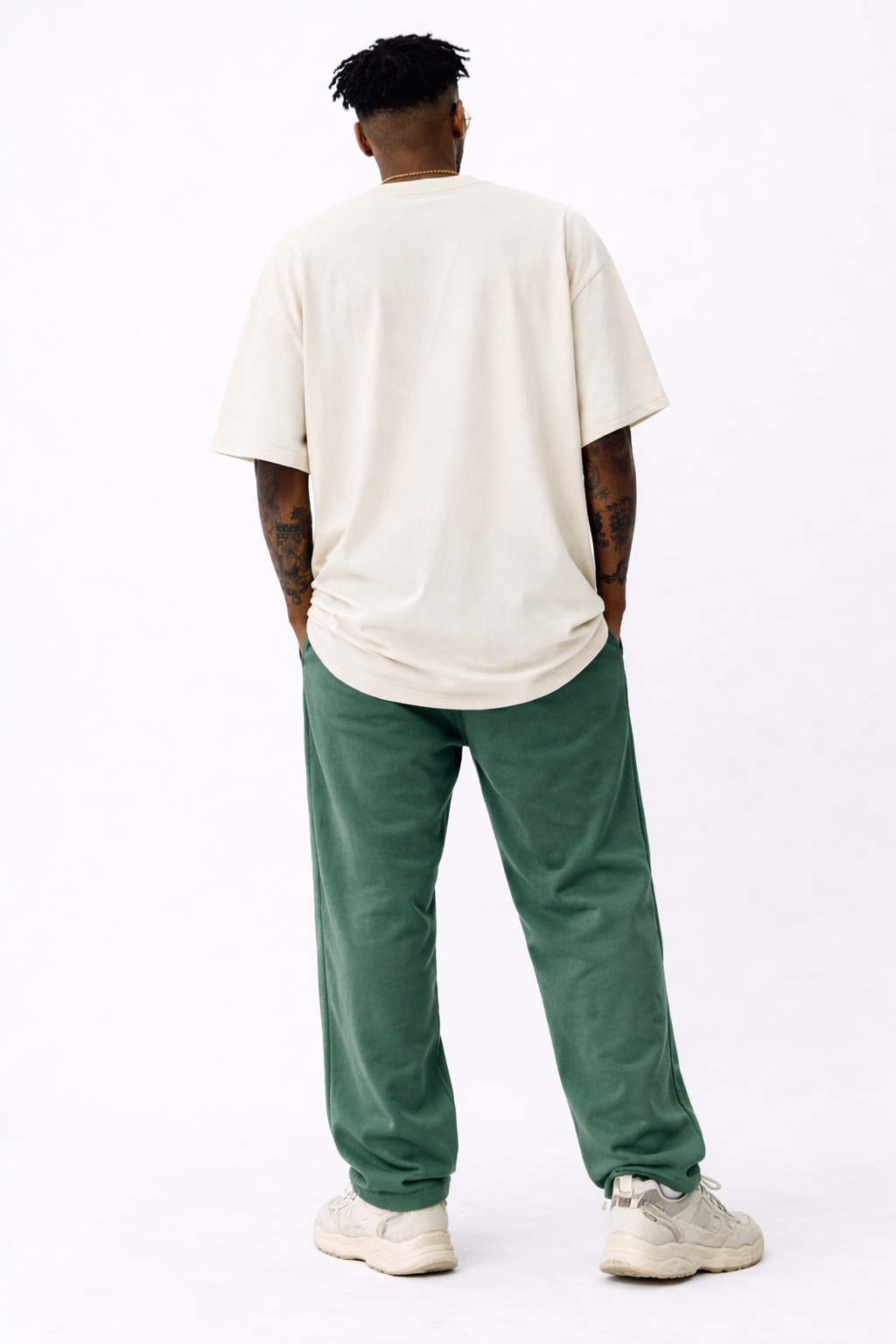 male model back view standing wearing oversized cream streetwear t shirt blank back minimalist streetwear outfit