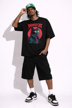 Full body male model wearing oversized black graphic streetwear t-shirt with badass cat artwork