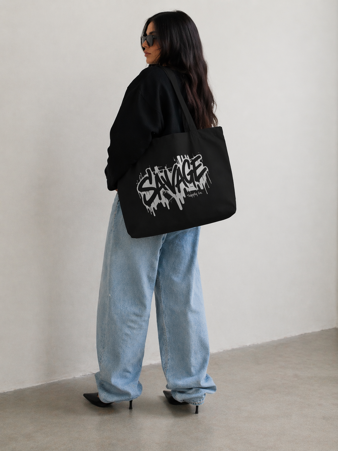 model standing back view wearing black tote bag savage graphic design streetwear fashion