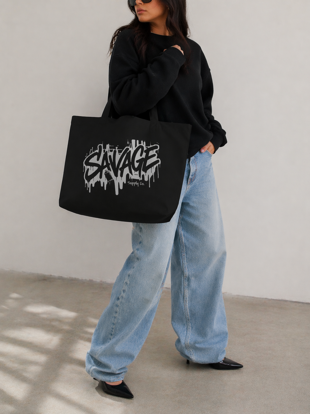 model walking rear angle holding black tote bag savage typography graphic streetwear