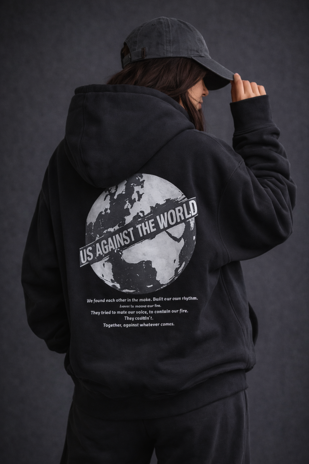 Female model back detail wearing oversized black graphic streetwear hoodie world tour typography graphic urban streetwear clothing