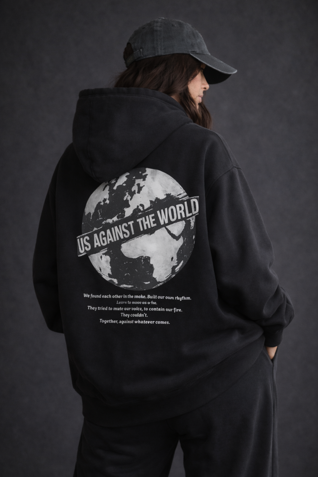 female model back view wearing oversized black graphic streetwear hoodie world tour typography design urban streetwear outfit