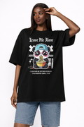 Female model wearing oversized black urban graphic t-shirt with Leave Me Alone panda noodles streetwear design