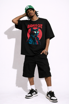 Man in oversized black streetwear graphic t-shirt featuring badass cat illustration urban fashion outfit