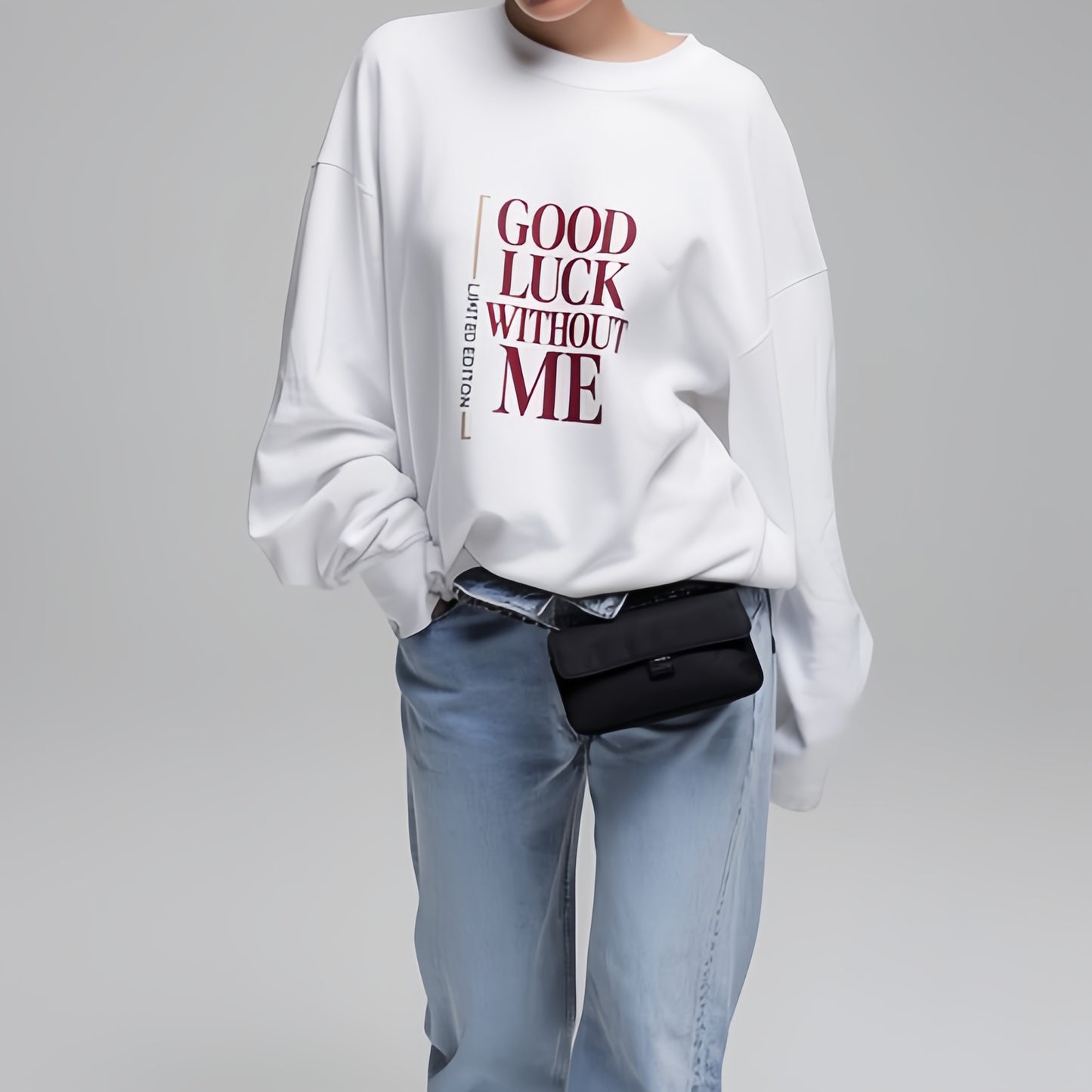 Model wearing white graphic sweatshirt with “Good Luck Without Me” typography, minimalist lifestyle studio photo