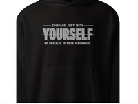 Close-up of “Compare just with yourself, no one else is your benchmark” motivational typography print on black unisex hoodie
